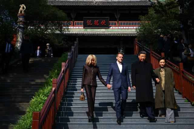 French President Emmanuel Macron (2nd L), his wife Brigitte Macron (L), Chinese President Xi Jinping (2nd R) and his wife Peng Liyuan (R) visit the Dujiangyan site, a designated UNESCO World Heritage site, in Dujiangyan, in southwestern China's Sichuan province on December 5, 2025. (Photo by Sarah Meyssonnier / POOL / AFP)