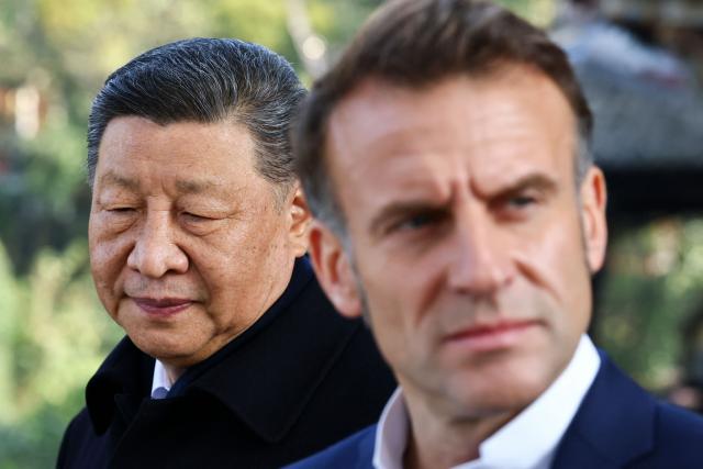 Chinese President Xi Jinping (L) and French President Emmanuel Macron visit the Dujiangyan site, a designated UNESCO World Heritage site, in Dujiangyan, in southwestern China's Sichuan province on December 5, 2025. (Photo by Sarah Meyssonnier / POOL / AFP)