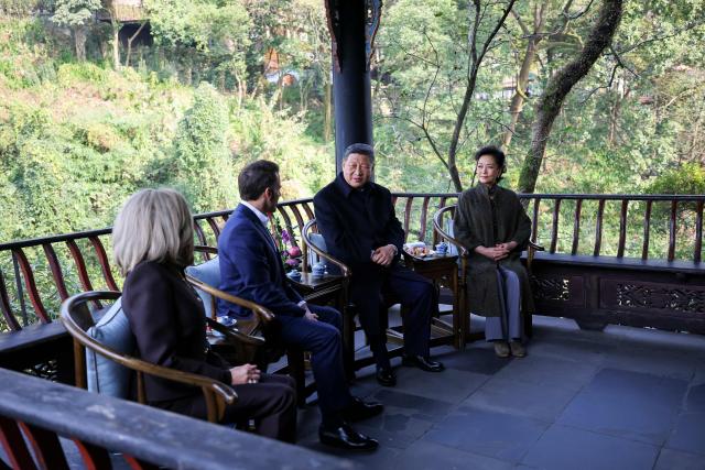 French President Emmanuel Macron (2nd L), his wife Brigitte Macron (L), Chinese President Xi Jinping (2nd R) and his wife Peng Liyuan visit the Dujiangyan site, a designated UNESCO World Heritage site, in Dujiangyan, in southwestern China's Sichuan province on December 5, 2025. (Photo by Sarah Meyssonnier / POOL / AFP)