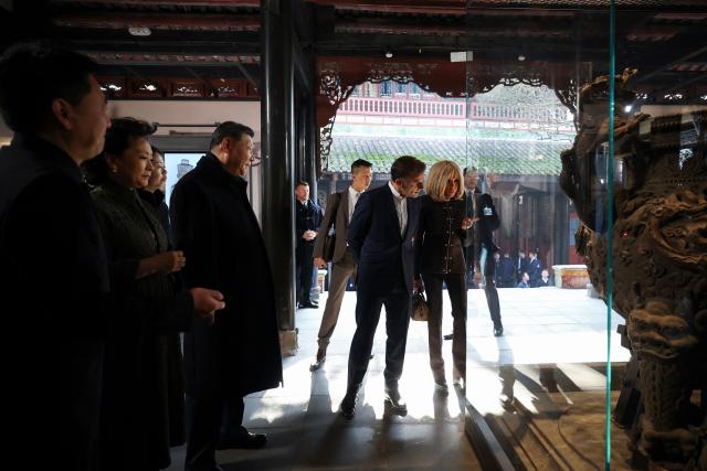 French President Emmanuel Macron (C), his wife Brigitte Macron (R), Chinese President Xi Jinping (4th L) and his wife Peng Liyuan (2nd L) visit the Dujiangyan site, a designated UNESCO World Heritage site, in Dujiangyan, in southwestern China's Sichuan province on December 5, 2025. (Photo by Sarah Meyssonnier / POOL / AFP)