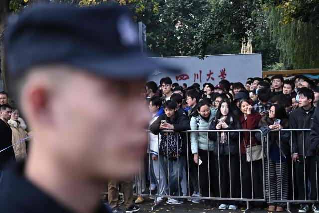 People wait for the arrival of French President Emmanuel Macron at the University of Sichuan for a meeting with students in Chengdu, in southwestern China's Sichuan province on December 5, 2025. (Photo by Pedro Pardo / AFP)