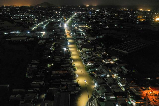 TOPSHOT - This aerial photo shows flood waters along a road in Vietnam's Lam Dong province on December 5, 2025, following weeks of heavy rain. South-central Vietnam has been lashed by weeks of heavy rain, submerging hundreds of thousands of homes in popular coastal tourism hotspots and causing deadly landslides in mountainous regions. (Photo by Quoc Nguyen / AFP)