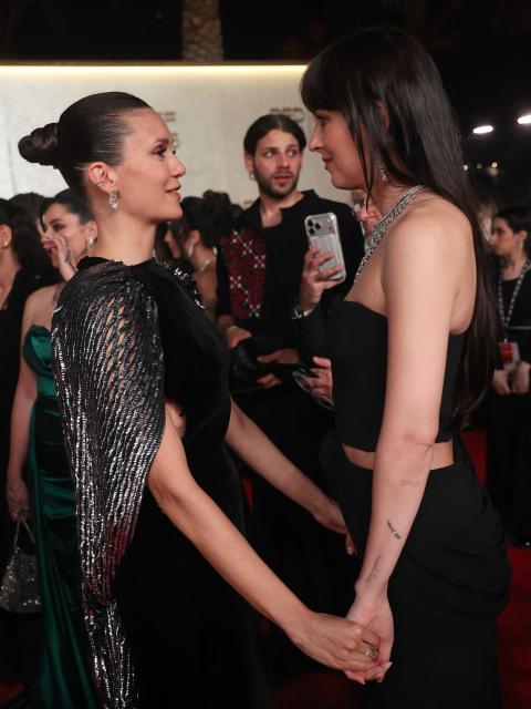 US actress Dakota Johnson (R) speaks with Candian actress Nina Dobrev as they arrive during the opening ceremony of the 5th edition of the Red Sea Film Festival in Jeddah on December 4, 2025. (Photo by PATRICK BAZ / Factstory for the Red Sea International Festival (RSFF) / AFP)