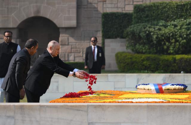 In this pool photograph distributed by the Russian state agency Sputnik, Russia's President Vladimir Putin pays his respect at the Mahatma Gandhi memorial at Rajghat in New Delhi on December 5, 2025. India's Prime Minister Narendra Modi hosts Russia's President Vladimir Putin at a summit on December 5, with defence and trade ties centre stage as New Delhi faces heavy US pressure to stop buying Moscow's oil. (Photo by Grigory SYSOYEV / POOL / AFP) / ***Editor's note : this image is distributed by the Russian state owned agency Sputnik***