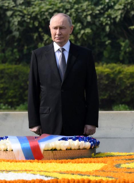 In this pool photograph distributed by the Russian state agency Sputnik, Russia's President Vladimir Putin pays his respect at the Mahatma Gandhi memorial at Rajghat in New Delhi on December 5, 2025. India's Prime Minister Narendra Modi hosts Russia's President Vladimir Putin at a summit on December 5, with defence and trade ties centre stage as New Delhi faces heavy US pressure to stop buying Moscow's oil. (Photo by Grigory SYSOYEV / POOL / AFP) / ***Editor's note : this image is distributed by the Russian state owned agency Sputnik***