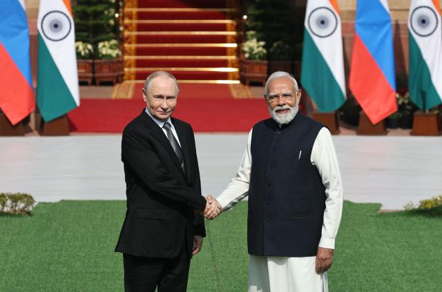 In this pool photograph distributed by the Russian state agency Sputnik, Russia's President Vladimir Putin shakes hands with India's Prime Minister Narendra Modi prior to their talks at the Hyderabad House in New Delhi on December 5, 2025. (Photo by Mikhail TERESHCHENKO / POOL / AFP) / ***Editor's note : this image is distributed by the Russian state owned agency Sputnik***