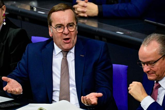 German Defence Minister Boris Pistorius reacts as he listens to a speech by Die Linke (Left party) MP Desiree Becker during a plenary session at the Bundestag, Germany's lower house of parliament in Berlin on December 5, 2025. German MP's are voting on a controversial pension package and a new military service plan. (Photo by John MACDOUGALL / AFP)