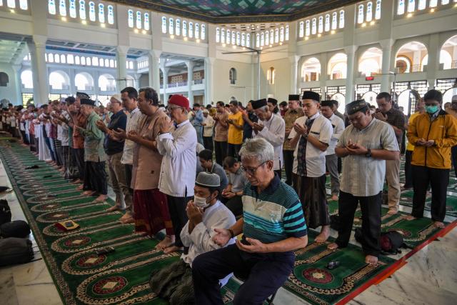 Muslims pray for flood victims in North Sumatra, West Sumatra, and Aceh, at the Al Akbar Mosque in Surabaya on December 5, 2025. Survivors in Indonesia were piecing back shattered lives December 5 after devastating floods killed more than 1,500 people across four countries, with fears of fresh misery as more rain looms. (Photo by JUNI KRISWANTO / AFP)