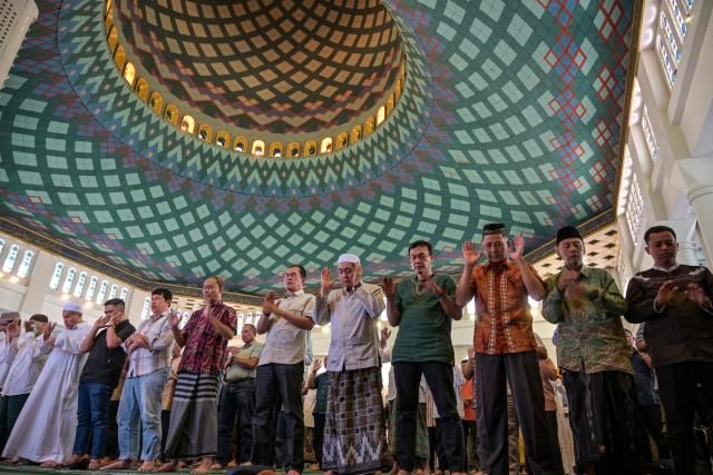 Muslims pray for flood victims in North Sumatra, West Sumatra, and Aceh, at the Al Akbar Mosque in Surabaya on December 5, 2025. Survivors in Indonesia were piecing back shattered lives December 5 after devastating floods killed more than 1,500 people across four countries, with fears of fresh misery as more rain looms. (Photo by JUNI KRISWANTO / AFP)