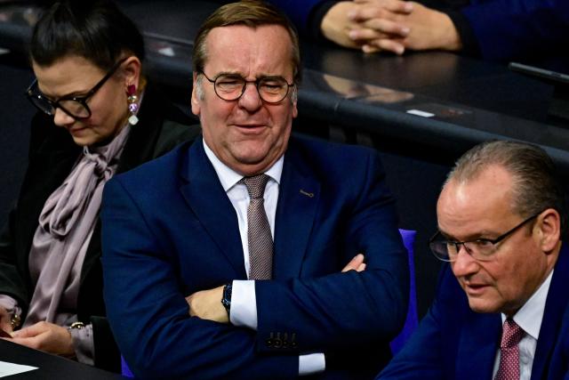 German Defence Minister Boris Pistorius reacts as he listens to a speech by Die Linke (Left party) MP Desiree Becker during a plenary session at the Bundestag, Germany's lower house of parliament in Berlin on December 5, 2025. German MP's are voting on a controversial pension package and a new military service plan. (Photo by John MACDOUGALL / AFP)