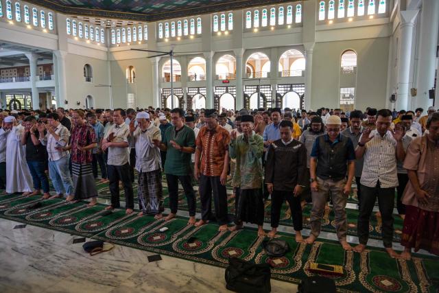 Muslims pray for flood victims in North Sumatra, West Sumatra, and Aceh, at the Al Akbar Mosque in Surabaya on December 5, 2025. Survivors in Indonesia were piecing back shattered lives December 5 after devastating floods killed more than 1,500 people across four countries, with fears of fresh misery as more rain looms. (Photo by JUNI KRISWANTO / AFP)