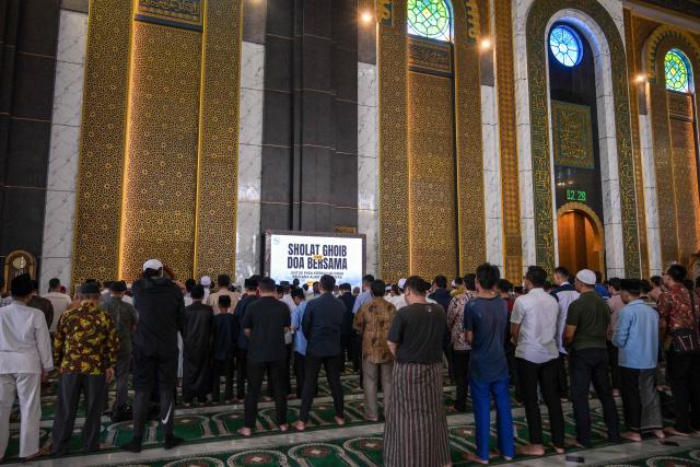 Muslims pray for flood victims in North Sumatra, West Sumatra, and Aceh, at the Al Akbar Mosque in Surabaya on December 5, 2025. Survivors in Indonesia were piecing back shattered lives December 5 after devastating floods killed more than 1,500 people across four countries, with fears of fresh misery as more rain looms. (Photo by JUNI KRISWANTO / AFP)