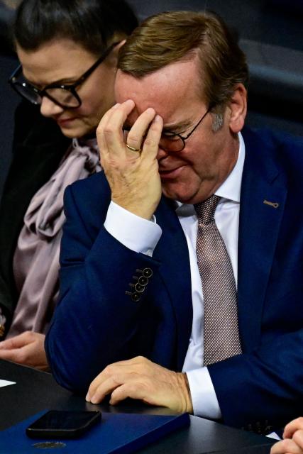 German Defence Minister Boris Pistorius reacts as he listens to a speech by Die Linke (Left party) MP Desiree Becker during a plenary session at the Bundestag, Germany's lower house of parliament in Berlin on December 5, 2025. German MP's are voting on a controversial pension package and a new military service plan. (Photo by John MACDOUGALL / AFP)