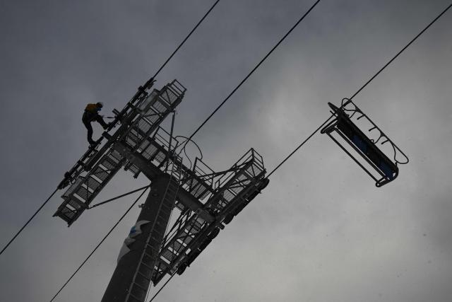 A technician works on a chairlift pylon at the Gourette ski resort near the Col d'Aubisque pass in the Pyrenees, south-western France on December 2, 2025. The family-oriented resort features one of the largest beginner areas in the Pyrenees and is a pioneer in the mountain range where skiing was first introduced in 1903 near Col d'Aubisque pass. (Photo by Philippe LOPEZ / AFP)