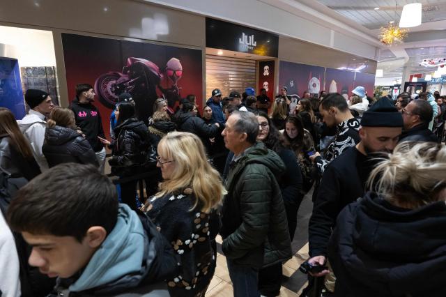 Customers wait at the entrance of the pop-up store of French rapper Jul on the day of its opening in Marseille, southern France on December 5, 2025. (Photo by Miguel MEDINA / AFP)