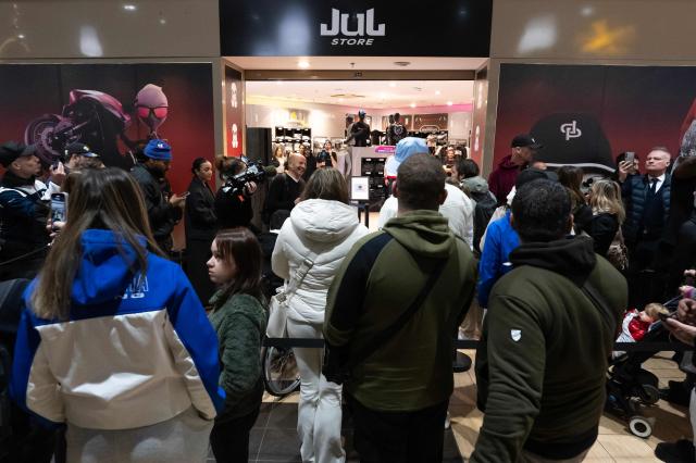 Customers wait at the entrance of the pop-up store of French rapper Jul on the day of its opening in Marseille, southern France on December 5, 2025. (Photo by Miguel MEDINA / AFP)