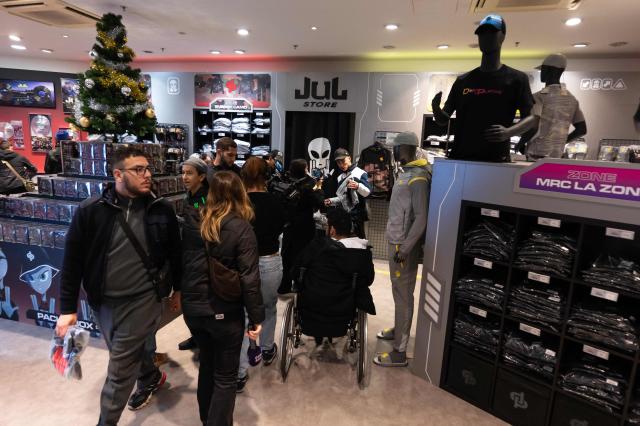 Customers walk through the pop-up store of French rapper Jul on the day of its opening in Marseille, southern France on June 7, 2024 (Photo by Miguel MEDINA / AFP)