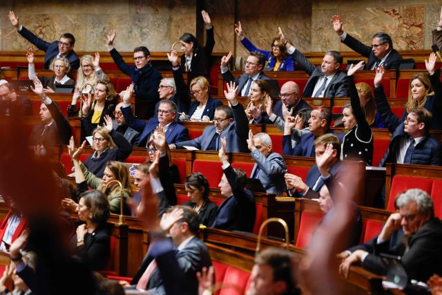 Members of Parliament take part in a vote during the voting session of amendments focused on the 2026 social security budget bill (PLFSS) at the National Assembly, the French Parliament lower house, in Paris on December 5, 2025. (Photo by Ian LANGSDON / AFP)