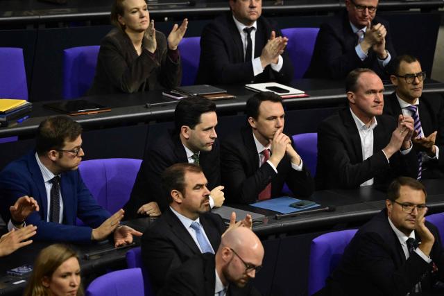 Johannes Winkel (centre,L), leader of the youth organisation "Junge Union" (young union, JU) of Germany's Christian Democratic Union (CDU) party, and JU member Pascal Reddig (centre,R)reacts as fellow CDU MP's applaud the passing of a bill JU opposed at Bundestag, Germany's lower house of parliament in Berlin on December 5, 2025. German MP's are voting on a controversial pension package and a new military service plan. (Photo by John MACDOUGALL / AFP)