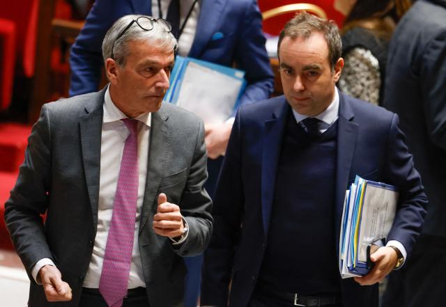 TOPSHOT - France's Prime Minister Sebastien Lecornu (C) and Les Democrates' MP Philippe Vigier leave after MPs adopted the "revenue" section during a voting session focused on the 2026 social security budget bill (PLFSS) at the National Assembly, the French Parliament lower house, in Paris on December 5, 2025. (Photo by Ian LANGSDON / AFP)