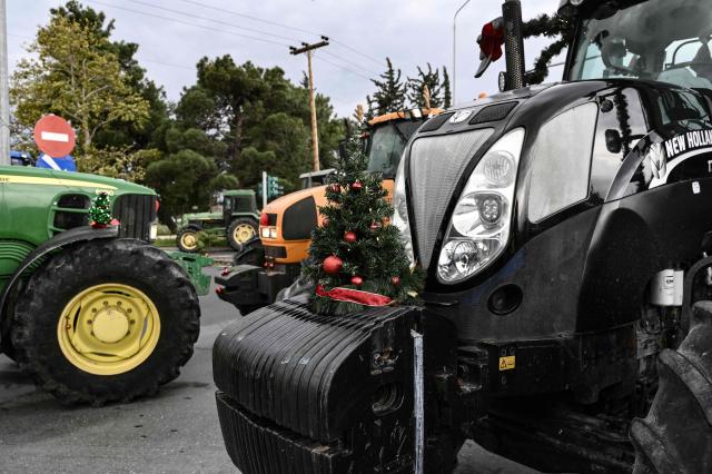 Christmas trees are placed on tractors as farmers block the road leading to the airport of Thessaloniki, with tractors during a protest over the reduced and delayed payment of European Union subsidies, on December 5, 2025. (Photo by Sakis Mitrolidis / AFP)