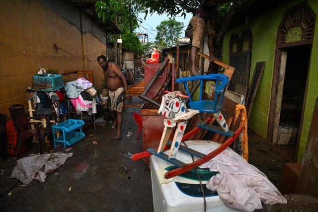 Residents remove remnants of their belongings from inundated homes following flash floods in the aftermath of cyclone Ditwah, in Wellampitiya on the outskirts of Colombo on December 5, 2025. The death toll from Sri Lanka's devastating floods and landslides rose to 607 on December 5 as hopes faded for another 214 still missing, the Disaster Management Centre said. (Photo by Ishara S. KODIKARA / AFP)