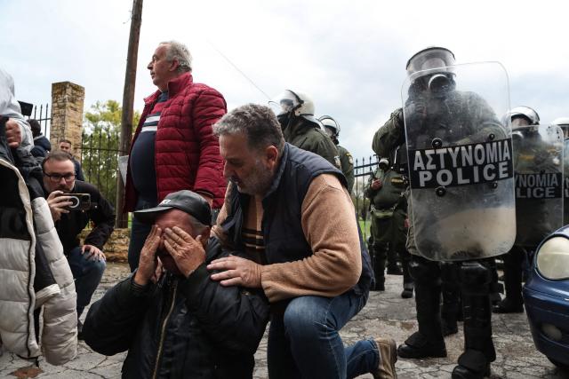 A protestor suffers from the teargas fired by riot police as farmers block the road leading to the airport with their tractors during a protest over the reduced and delayed payment of European Union subsidies, in Thessaloniki on December 5, 2025. (Photo by AFP)