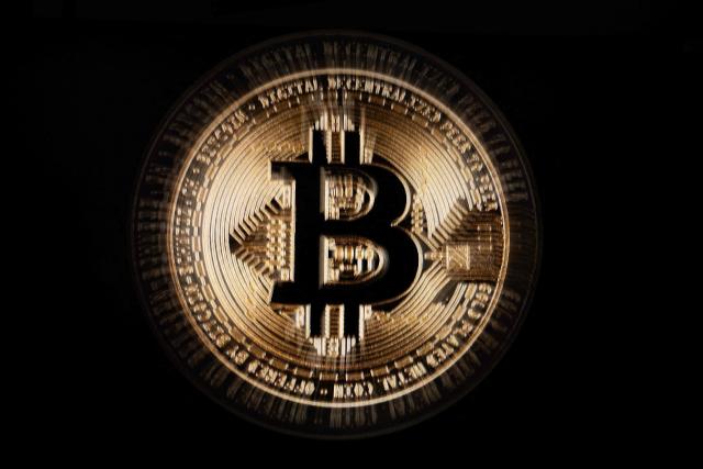 This illustration photograph shows a screen displaying a Bitcoin logo, in Mulhouse on December 5, 2025. (Photo by SEBASTIEN BOZON / AFP)