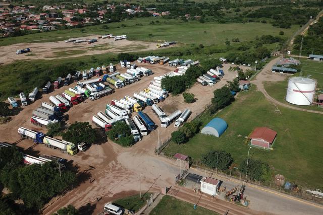 Aerial view of trucks at the Guillermo Elder Bell refinery of Bolivian state-owned oil company YPFB in Santa Cruz, Bolivia, on December 5, 2025. On Tuesday, Bolivia's new centre-right government denounced the misappropriation of millions of dollars worth of fuel under previous administrations of the Movement Towards Socialism (MAS) party, which even impacted the country during the recent fuel shortage crisis. This week, the public prosecutor's office raided the state oil company YPFB and the National Hydrocarbons Agency, which are under investigation for alleged corruption. (Photo by Rodrigo URZAGASTI / AFP)