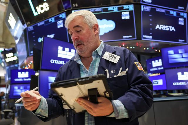 A trader works on the floor of the New York Stock Exchange (NYSE) on December 5, 2025 in New York City. Wall Street stocks advanced early Friday ahead of US inflation data, while Netflix dipped after announcing a deal to acquire Warner Bros. Discovery for $83 billion. (Photo by ANGELA WEISS / AFP)