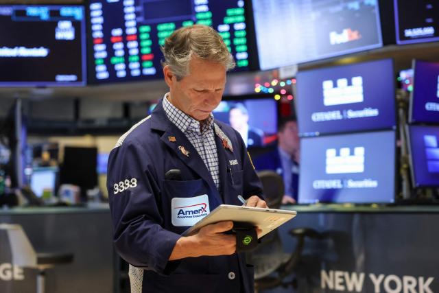 A trader works on the floor of the New York Stock Exchange (NYSE) on December 5, 2025 in New York City. Wall Street stocks advanced early Friday ahead of US inflation data, while Netflix dipped after announcing a deal to acquire Warner Bros. Discovery for $83 billion. (Photo by ANGELA WEISS / AFP)