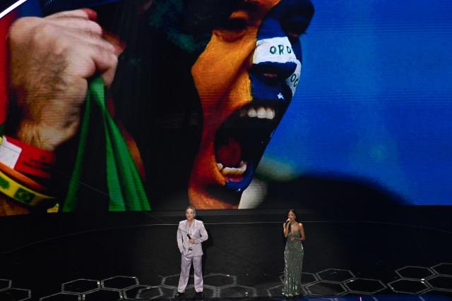 (L-R) British Singer songwriter Robbie Williams and US singer Nicole Scherzinger perform on stage during the draw for the 2026 FIFA Football World Cup taking place in the US, Canada and Mexico, at the Kennedy Center, in Washington, DC, on December 5, 2025. (Photo by Roberto SCHMIDT / AFP)