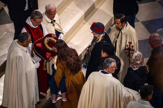 Faithfuls pray at the Holy Crown of Thorns during the veneration of the Holy Crown of Thorns at cathedral of Notre-Dame of Paris, in Paris on December 5, 2025. (Photo by Dimitar DILKOFF / AFP)