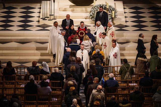 Faithfuls pray at the Holy Crown of Thorns during the veneration of the Holy Crown of Thorns at cathedral of Notre-Dame of Paris, in Paris on December 5, 2025. (Photo by Dimitar DILKOFF / AFP)
