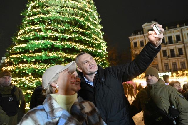 Kyiv's mayor Vitali Klitschko takes selfie pictures with local residents during the unveiling ceremony of Kyiv's main Christmas tree on the St. Sophia Square in the Ukrainian capital of Kyiv, on December 5, 2025, amid the Russian invasion of Ukraine. (Photo by Genya SAVILOV / AFP)