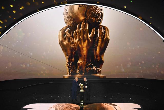 (L-R) US President Donald Trump shakes hands with FIFA President Gianni Infantino as he receives the FIFA Peace Prize during the draw for the 2026 FIFA Football World Cup taking place in the US, Canada and Mexico, at the Kennedy Center, in Washington, DC, on December 5, 2025. (Photo by Roberto SCHMIDT / AFP)