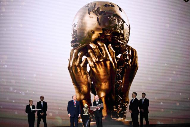 (L/R) US President Donald Trump looks on as he receives the FIFA Peace Prize from FIFA President Gianni Infantino during the draw for the 2026 FIFA Football World Cup taking place in the US, Canada and Mexico, at the Kennedy Center, in Washington, DC, on December 5, 2025. (Photo by Brendan SMIALOWSKI / AFP)