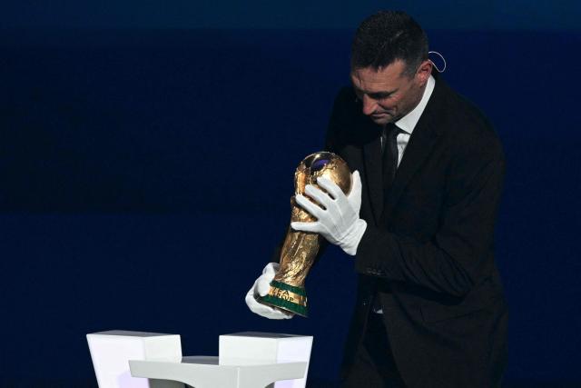 Argentina's head coach Lionel Scaloni places on a pedestal the World Cup Trophy during the draw for the 2026 FIFA Football World Cup taking place in the US, Canada and Mexico, at the Kennedy Center, in Washington, DC, on December 5, 2025. (Photo by Jim WATSON / AFP)