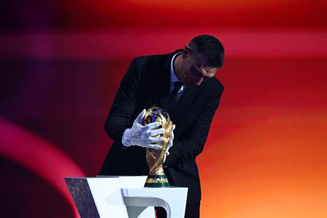 Argentina's head coach Lionel Scaloni places the FIFA World Cup trophy on stage during the draw for the 2026 FIFA Football World Cup taking place in the US, Canada and Mexico, at the Kennedy Center, in Washington, DC, on December 5, 2025. (Photo by SAUL LOEB / AFP)