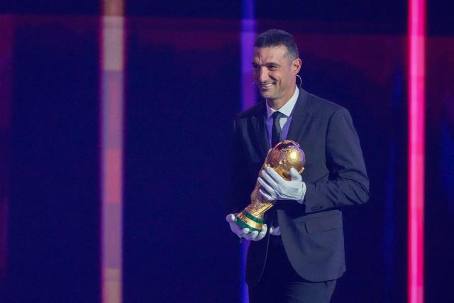 Argentina's head coach Lionel Scaloni carries the World Cup Trophy on stage during the draw for the 2026 FIFA Football World Cup taking place in the US, Canada and Mexico, at the Kennedy Center, in Washington, DC, on December 5, 2025. (Photo by Stephanie Scarbrough / POOL / AFP)