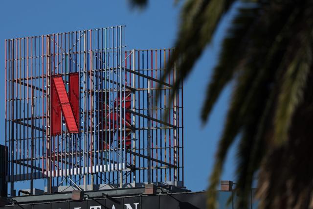 The Netflix logo is pictured across from Hollywood studio offices in Los Angeles, California on December 5, 2025. Streaming giant Netflix said December 5, 2025 it will buy film and television studio Warner Bros. Discovery for nearly $83 billion, the entertainment industry's biggest consolidation deal this decade. The acquisition gives Netflix access to a vast film catalog as well as the prestigious streaming service HBO Max. (Photo by Patrick T. Fallon / AFP)