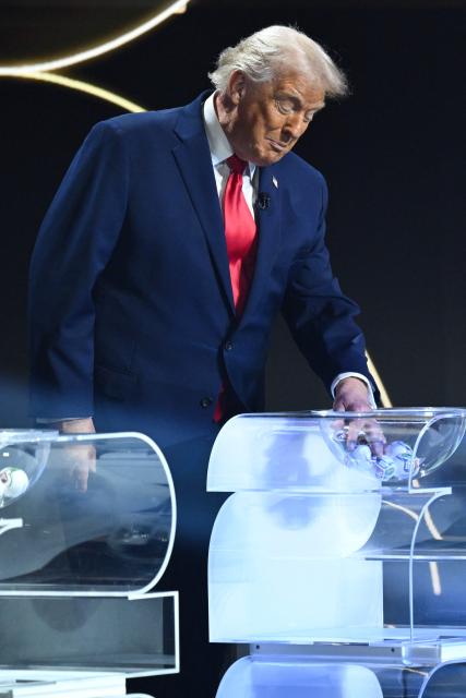 US President Donald Trump picks up a card during the draw for the 2026 FIFA Football World Cup taking place in the US, Canada and Mexico, at the Kennedy Center, in Washington, DC, on December 5, 2025. (Photo by SAUL LOEB / AFP)