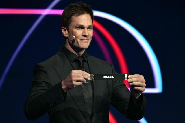 US football player Tom Brady shows the card reading Brazil during the draw for the 2026 FIFA Football World Cup taking place in the US, Canada and Mexico, at the Kennedy Center, in Washington, DC, on December 5, 2025. (Photo by Jim WATSON / AFP)