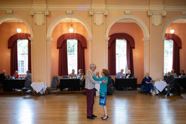 Ballroom dancers take part in an afternoon Tea Dance in the Riley-Smith Hall, in Tadcaster, northern England on October 15, 2025. Tea dances, which evolved from the tradition of afternoon tea in the late 19th century, are enjoying a revival, especially since the pandemic. Often cited as an effective way to combat loneliness, the dances are also attributed to improving the participants' mental and physical health. Frequently hosted in Victorian and Edwardian-era halls, tea dances typically offer a mixture of ballroom and sequence dancing styles and feature refreshments of tea, coffee and cakes. (Photo by Oli SCARFF / AFP)