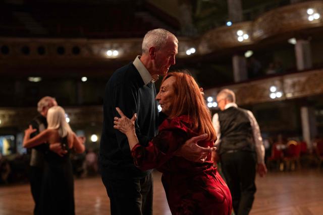 Ballroom dancers take part in a Tea Dance, accompanied by a live organist, in the Blackpool Tower Ballroom, in Blackpool, north west England on October 22, 2025. Tea dances, which evolved from the tradition of afternoon tea in the late 19th century, are enjoying a revival, especially since the pandemic. Often cited as an effective way to combat loneliness, the dances are also attributed to improving the participants' mental and physical health. Frequently hosted in Victorian and Edwardian-era halls, tea dances typically offer a mixture of ballroom and sequence dancing styles and feature refreshments of tea, coffee and cakes. (Photo by Oli SCARFF / AFP)