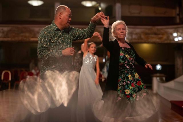 Ballroom dancers take part in a Tea Dance, accompanied by a live organist, in the Blackpool Tower Ballroom, in Blackpool, north west England on October 22, 2025. Tea dances, which evolved from the tradition of afternoon tea in the late 19th century, are enjoying a revival, especially since the pandemic. Often cited as an effective way to combat loneliness, the dances are also attributed to improving the participants' mental and physical health. Frequently hosted in Victorian and Edwardian-era halls, tea dances typically offer a mixture of ballroom and sequence dancing styles and feature refreshments of tea, coffee and cakes. (Photo by Oli SCARFF / AFP)