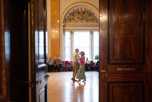 Ballroom dancers take part in a Tea Dance, in the Main Ballroom of Liverpool Town Hall, in Liverpool, north west England on November 17, 2025. Tea dances, which evolved from the tradition of afternoon tea in the late 19th century, are enjoying a revival, especially since the pandemic. Often cited as an effective way to combat loneliness, the dances are also attributed to improving the participants' mental and physical health. Frequently hosted in Victorian and Edwardian-era halls, tea dances typically offer a mixture of ballroom and sequence dancing styles and feature refreshments of tea, coffee and cakes. (Photo by Oli SCARFF / AFP)