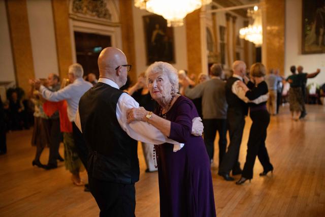 Ballroom dancers take part in a Tea Dance, in the Main Ballroom of Liverpool Town Hall, in Liverpool, north west England on November 17, 2025. Tea dances, which evolved from the tradition of afternoon tea in the late 19th century, are enjoying a revival, especially since the pandemic. Often cited as an effective way to combat loneliness, the dances are also attributed to improving the participants' mental and physical health. Frequently hosted in Victorian and Edwardian-era halls, tea dances typically offer a mixture of ballroom and sequence dancing styles and feature refreshments of tea, coffee and cakes. (Photo by Oli SCARFF / AFP)