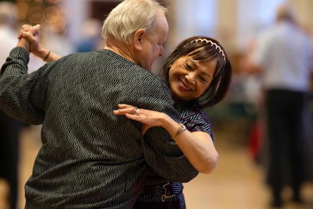 Ballroom dancers take part in a Tea Dance in Dukinfield Town Hall, near Ashton-under-Lyne, north west England on December 1, 2025. Tea dances, which evolved from the tradition of afternoon tea in the late 19th century, are enjoying a revival, especially since the pandemic. Often cited as an effective way to combat loneliness, the dances are also attributed to improving the participants' mental and physical health. Frequently hosted in Victorian and Edwardian-era halls, tea dances typically offer a mixture of ballroom and sequence dancing styles and feature refreshments of tea, coffee and cakes. (Photo by Oli SCARFF / AFP)