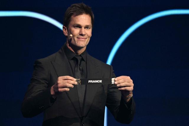 US football player Tom Brady shows the card reading France during the draw for the 2026 FIFA Football World Cup taking place in the US, Canada and Mexico, at the Kennedy Center, in Washington, DC, on December 5, 2025. (Photo by Jim WATSON / AFP)